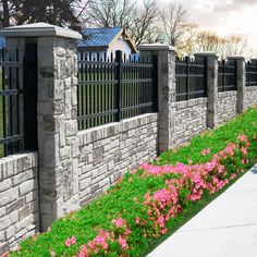 a stone fence with flowers growing next to it