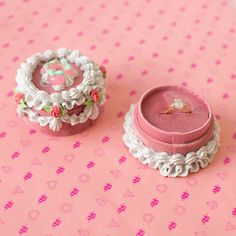 two small pink boxes sitting on top of a table