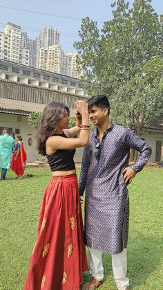 a man and woman standing next to each other in the grass