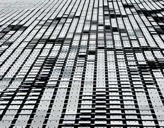 an abstract black and white photo of many rows of identical building blocks in the city