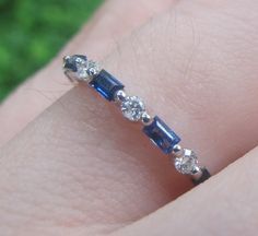 a woman's hand with a diamond and sapphire ring