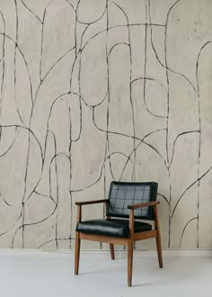 a chair sitting in front of a wall with lines painted on it