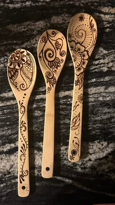 three wooden spoons with intricate designs on them