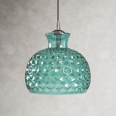 a green glass pendant light hanging from a ceiling fixture in a kitchen or dining room