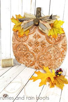 a wooden pumpkin with fall leaves on it