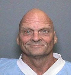 this is an image of a mug shot of a man with bald hair and blue eyes