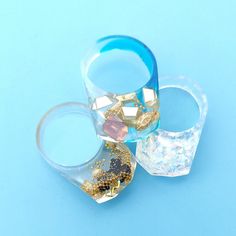 three clear cups with gold and blue decorations on them