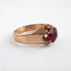 A vintage / antique ring in gold filled or gold shell with prong set faceted red center stone (stone shows wear and scratches).  A size 10 on my ring sizer (I would consider it unisex).  Marked "KMJ Co".  Solid weight at 4.4 grams.  I haven't polished or done anything to it.  Stone is 7mm in diameter. Please check out my store with similar things added almost daily. Remember, shipping for additional items is always free.