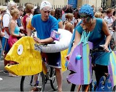 two people riding bikes with floaty fish on the back and man in blue shirt