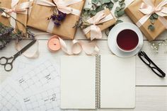 a cup of coffee and some presents on a table next to a spiral notepad