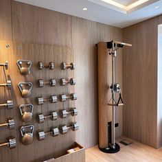 an exercise room with wooden walls and metal dumbbells on the wall next to a window