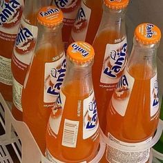 several bottles of orange soda sitting in a bin together on the shelf next to each other