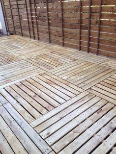 a wooden floor in front of a fence with wood slats on the sides and bottom