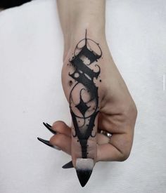 a woman's hand with a black ink tattoo on it