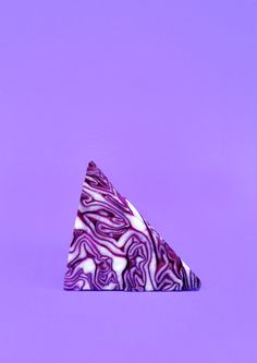 a purple and white marbled object on a purple background in the shape of a triangle