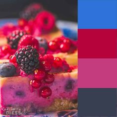 a cake with berries and blueberries on top is shown in the color red, purple, and yellow