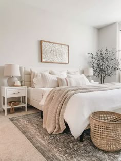 a bedroom with a large bed, white walls and rugs on top of the floor