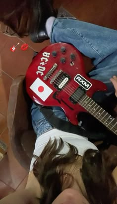 a person laying on the floor with a red guitar