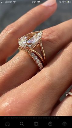 a woman's hand with a diamond ring on it and an engagement band in the middle