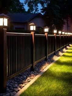 some lights that are on the side of a fence in the grass and bushes next to it