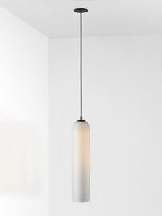 a light fixture hanging from the ceiling in a room with white walls and flooring