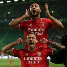 two soccer players with their mouths open in the air