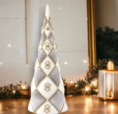 a white and grey christmas tree sitting on top of a wooden floor