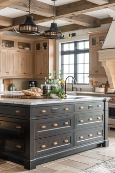 a large kitchen with an island in the middle of it and lots of lights hanging from the ceiling