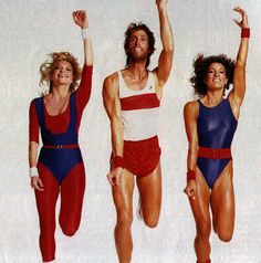 three women in swimsuits are jumping up and down with their arms raised to the sky