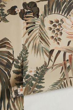 the wall paper has tropical leaves and flowers on it