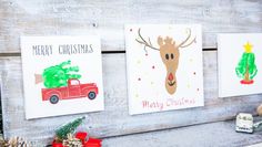 three christmas cards are hanging on a wooden wall next to pine cones and other holiday decorations