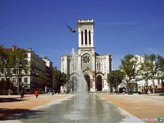 a fountain in front of a large building with a clock tower