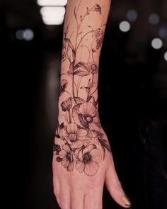 a woman's hand with flowers on it