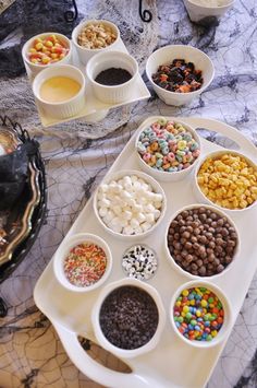 a tray filled with lots of different types of candy and toppings on top of it