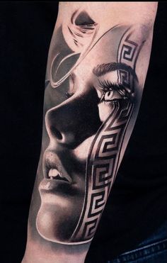 a man's arm with a black and white tattoo design on the arm,