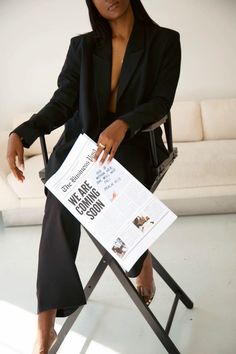 a woman sitting in a chair holding a paper