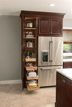 a kitchen with brown cabinets and stainless steel refrigerator freezer next to an open drawer