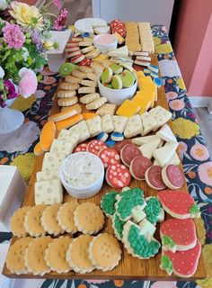 a table topped with lots of different types of cookies and crackers on top of a wooden cutting board