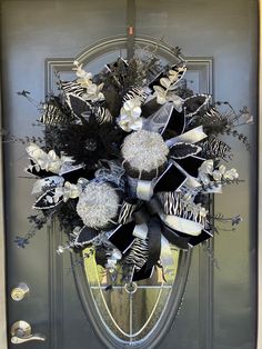 a zebra print wreath on the front door of a house with black and white decorations