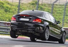 a black car driving down a race track