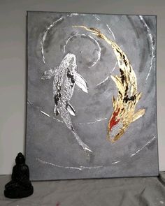 two gold and silver koi fish are depicted on a gray background, with a black buddha statue in the foreground