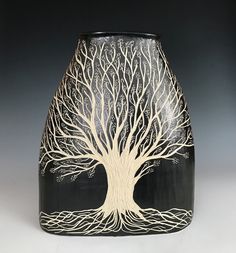 a black and white vase with a tree on it