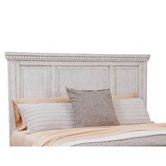 a bed with two pillows on top of it and a headboard made out of wood