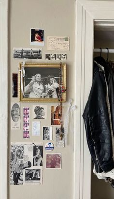 a black leather jacket hanging on the wall next to a coat rack with pictures and photos