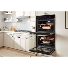 two open ovens in a kitchen with white cabinets