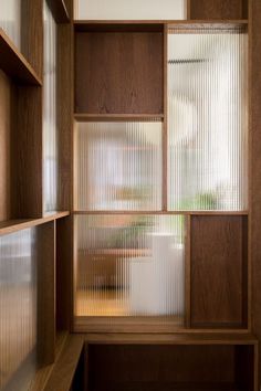 an empty wooden shelf in front of a window