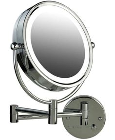 a mirror that is on top of a metal wall mounted holder with the light on it