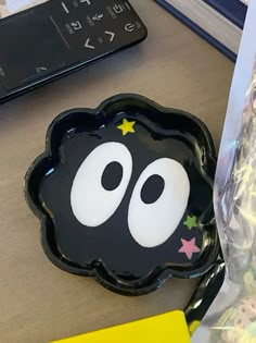 a black plate with white eyes and stars on it sitting next to a bag of candy