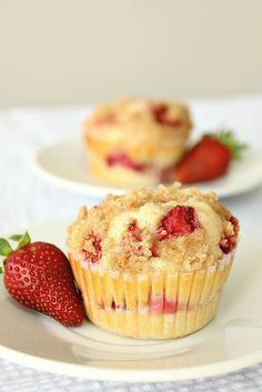 two strawberry muffins on a plate with strawberries