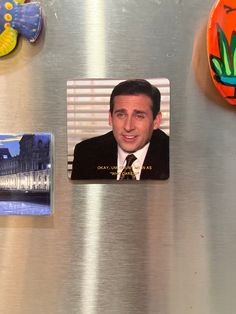 a refrigerator with magnets on the front and side of it that has a man in a suit